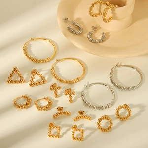 Assorted gold and silver titanium steel geometric stud earrings on ceramic display