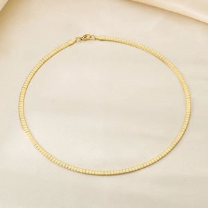Detailed top view of a gold flat snake chain necklace on beige silk fabric with lobster clasp