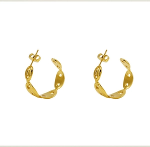 Macro shot of gold polished titanium steel hoop earrings with pig nose link design