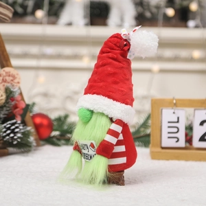 Gnome de Noël avec chapeau rouge et barbe verte tenant un panneau Merry Christmas