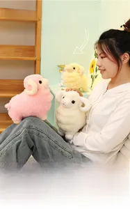 Close-up of soft sheep plush toys in pink, white and yellow with curly horns and embroidery