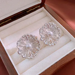 Elegante Blumen-Ohrstecker mit Perlen in einer luxuriösen Schmuckschatulle aus Holz