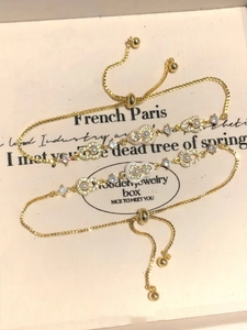 Détail de bracelets plaqués or 18k avec perles et zircons dans une boîte à bijoux