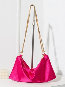 Fuchsia satin tote bag with gold double chains on a display stand with white background