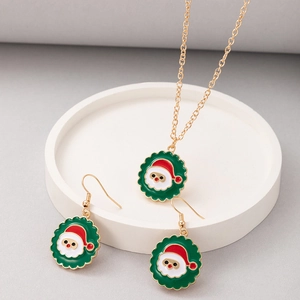 Detail view of Santa Claus enamel necklace and earrings set on a white round tray