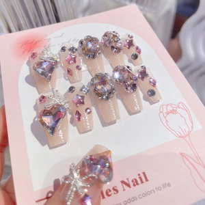 Detail of glitter pink press-on nails with 3D heart crystals and silver bows decoration