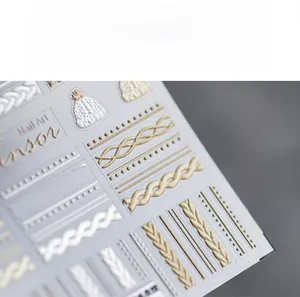 Macro view of 3D embossed nail stickers with white knit textures and gold woven lines