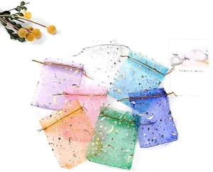 Close-up of colorful organza drawstring gift bags with gold star and moon patterns