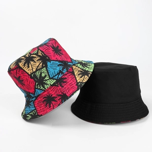 Reversible bucket hat with coconut palm tree print and solid black cotton canvas design