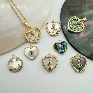 Close-up of 18K gold plated heart and rabbit charms with natural shell inlays