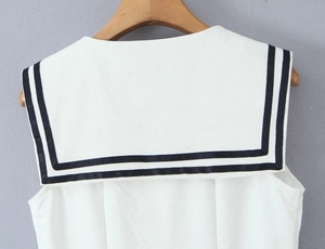 Detail of nautical sailor collar with navy blue stripes on white sleeveless dress