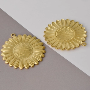 Macro shot of two gold 304 stainless steel sunflower pendants for DIY jewelry making