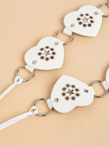 Detailed close-up of white heart-shaped faux leather belt with metal studs and star accents