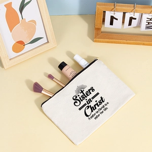 Detailed view of canvas Sisters in Christ makeup bag with black zipper and brushes