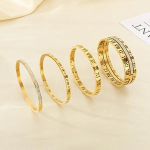 Golden titanium steel bangle set with Roman numerals and sparkling crystals on fabric