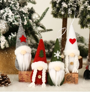 Close-up of four handmade Christmas gnome ornaments with festive felt hats and soft fur texture