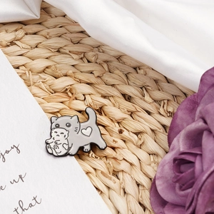 Cute enamel brooch featuring a grey cat carrying a white kitten with heart detail