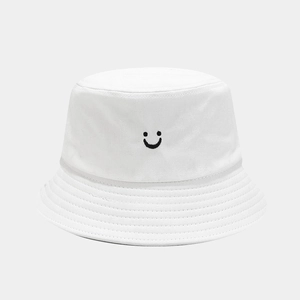 Close-up of black embroidered smile face on white cotton bucket hat with parallel stitching