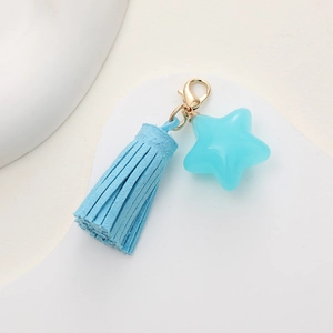 Blue star pendant keychain with velvet tassel and golden clasp on white background