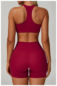 Vista posteriore set yoga bordeaux con reggiseno sportivo incrociato e pantaloncini a vita alta