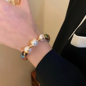 Detail of baroque pearl and colored gemstone wire-wrapped bracelet on model wrist