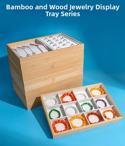 Macro detail of stackable bamboo jewelry display trays with white inserts on blue background