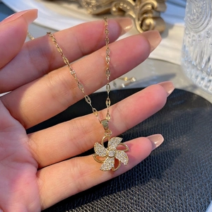 Elegant rotating windmill pendant necklace in gold-plated steel with sparkling crystals