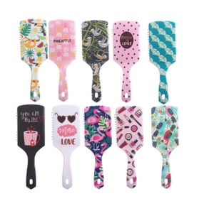Top view of ten assorted cartoon hairbrushes with pineapple and flamingo patterns