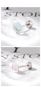 Detail of blue and pink moonstone screw back stud earrings in polished titanium steel