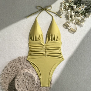 Deep V-neck lime green swimsuit with metallic luster and pleated waist on a flat lay surface
