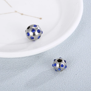 Macro shot of silver stainless steel beads with sparkling blue rhinestones for DIY jewelry