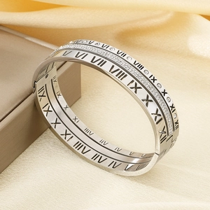 Detailed view of silver stainless steel bangle with Roman numerals and pavé cubic zirconia