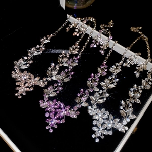 Close-up of sparkling leaf and flower crystal necklaces in pink, purple, and white