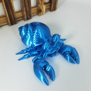 Articulated 3D printed hermit crab toy in metallic blue finish on white background