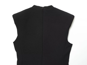 Dettaglio della cerniera invisibile sul retro sul tessuto strutturato nero del vestito
