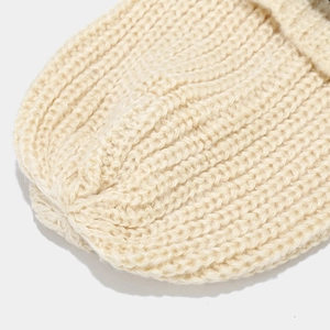 Primer plano de la textura de punto beige y las costuras del gorro de invierno cálido
