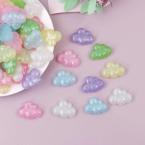 Sparkling resin cloud charms in pastel colors displayed on a white ceramic plate
