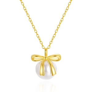 Detail shot of a gold bow and pearl pendant necklace on a sleek O-link chain over white