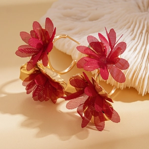 Detailed view of red fabric flower earrings on gold-tone hoops with delicate textile layers