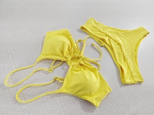 Flat lay of bright yellow halter neck bikini set with drawstring front detail