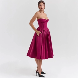 Elegante abito midi a corsetto magenta senza spalline con gonna a pieghe e tasche laterali