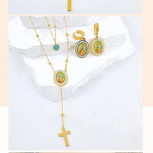Detail of gold religious jewelry set featuring cross pendant and Virgin Mary medallions