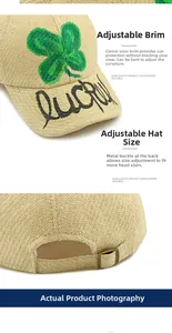 Detail of straw baseball cap showing lucky embroidery and adjustable metal buckle