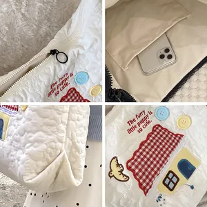 Quilted white tote bag with bird embroidery and zipper pocket shown in multi-angle detail