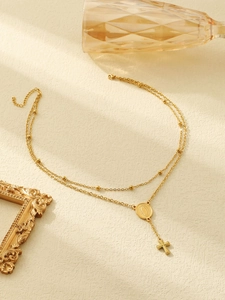 Detailed view of layered 18k gold-plated stainless steel cross necklace with Virgin Mary medal