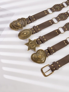 Detail of vintage PU leather belts with decorative bronze buckles and Western star motifs