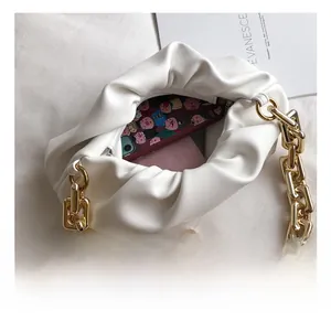 Detail view of the white pleated cloud bag interior showing capacity for phone and wallet