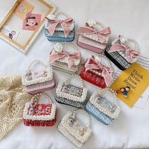 Détail de mini sacs en tweed avec poignées en perles, nœuds satinés et breloques lapin