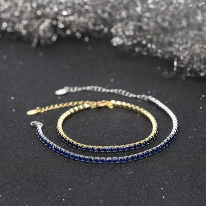 Detail of 3mm cubic zirconia tennis bracelets in gold and silver finish with blue stones
