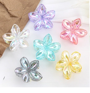 Flat lay of colorful plumeria flower hair claws with a shimmering laser finish